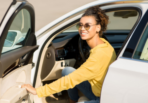 A woman in sunglasses exiting a car after a test drive near Orangeburg, South Carolina.