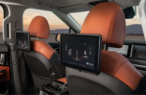 Two entertainment screens pointed at the rear seats inside of a 2024 Kia Carnival
