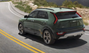 A 2024 Kia Niro Hybrid driving down a road in a dry, sandy area near Orangeburg, South Carolina