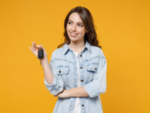 A person standing in front of a yellow background while holding a set of car keys near Orangeburg, South Carolina
