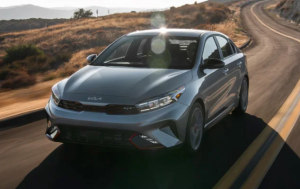 A photo of a 2024 Kia Forte driving down a winding road near Orangeburg, South Carolina